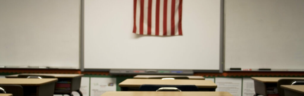 empty classroom with an American flag at the front of the room